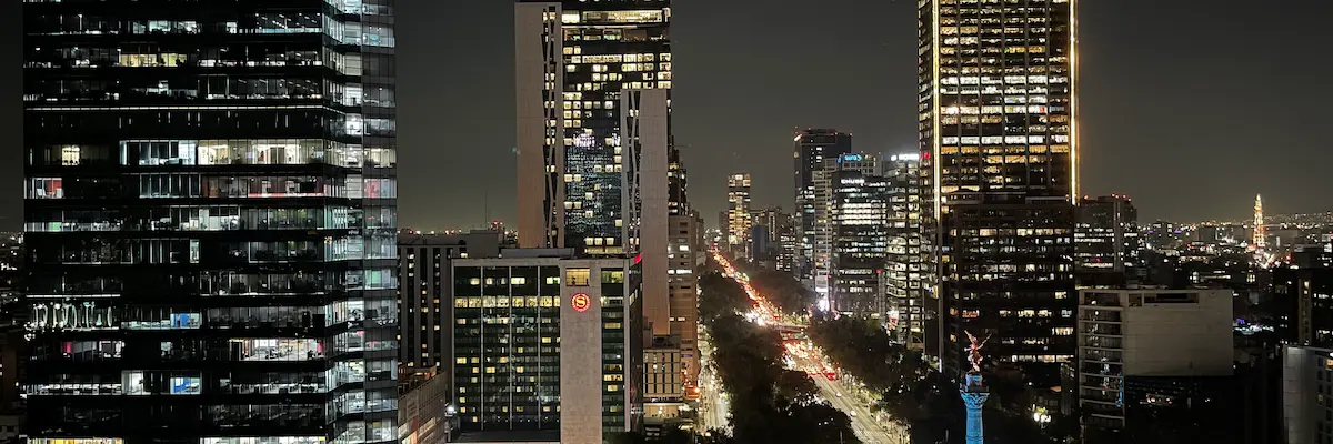 Night skyline of Mexico City along Paseo de la Reforma, with the Angel of Independence lit up
